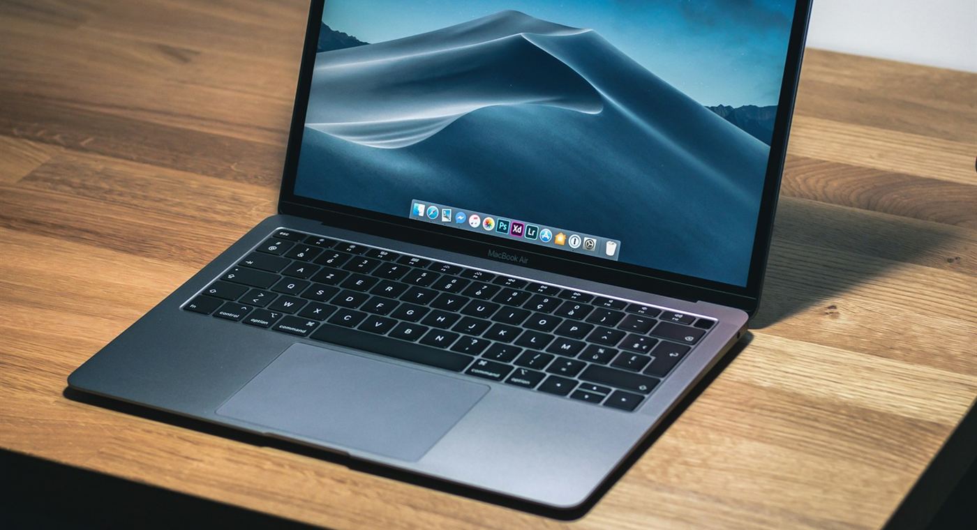 A MacBook Air open on a wooden desk.